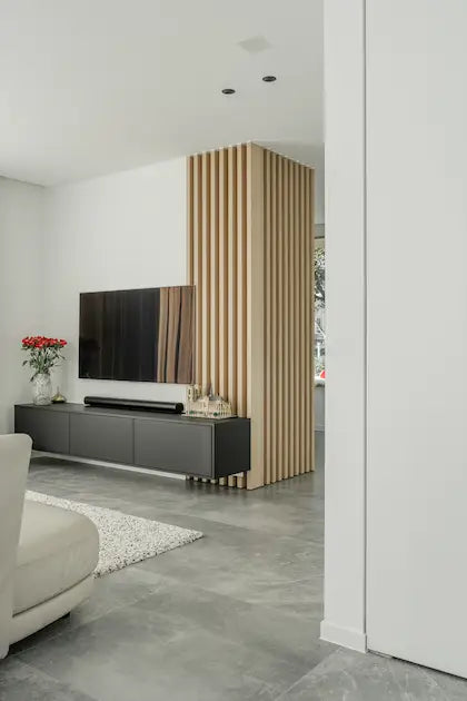 Een modern interieur met een tv, een soundbar en sfeervolle verlichting, ontworpen door Kompanjonn voor een ultieme woonbeleving
