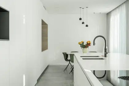 Licht en modern keukeninterieur met kookeiland, waar slimme technologie en design naadloos samenkomen door de expertise van Kompanjonn.